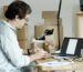 Businessman Packing Products And Managing An Online Store From His Desk With A Laptop.